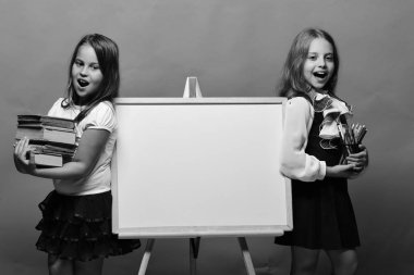 Mutlu yüzler ve ileti örneği ile kız. Yeşil arka plan beyaz tahtada yanındaki kız öğrenciler