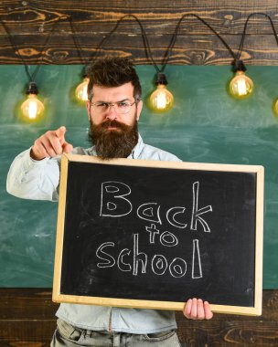 Geri okul kavramı. Gözlük öğretmen blackboard yazıt ile okula geri tutar. Adam sakal ve bıyık sıkı yüzündeki öğrenciler, uyardı ileri, arka plan kara tahta işaret