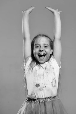 Çocukluk ve tatil kavramı. Kız mor arka plan üzerinde izole heyecanlı yüzü ile kapatın. Ponytails çocukla ellerini tutar. Kız öğrenci boya noktalar vardır