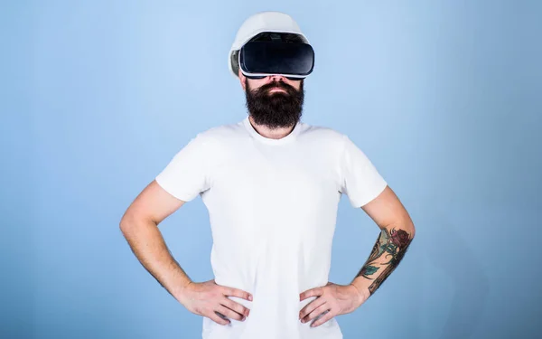 Man with beard in VR glasses serious and confident, light blue background. Architect or engineer with virtual reality glasses. Guy in helmet works as engineer in virtual reality. 3D design concept