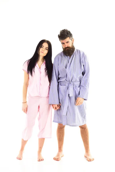Couple, family on sleepy faces in clothes for sleep looks sleepy in morning. Insomnia concept. Couple hold hands together, isolated on white background. Couple in love in pajama, bathrobe