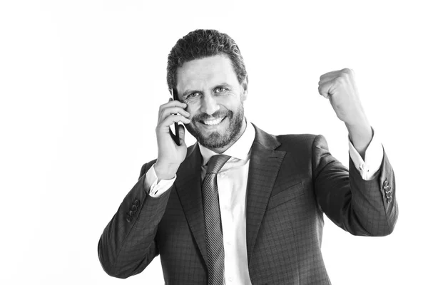 Concepto de tecnología y personas. Empresario con cara feliz sostiene el teléfono celular y levanta el puño . — Foto de Stock