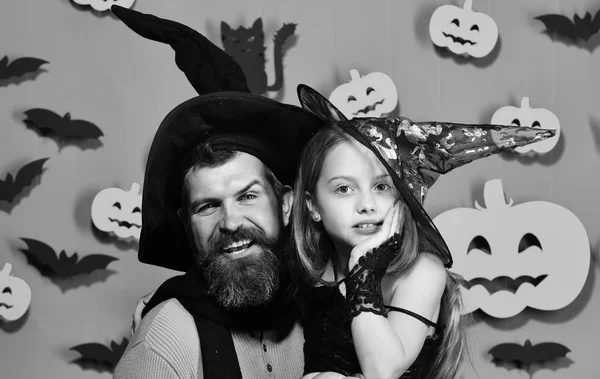 Dziewczyna i Brodaty mężczyzna z szczęśliwy twarze na zielonym tle w stylu. Kreator i mała czarownica w czarne kapelusze przytulić. Halloween party — Zdjęcie stockowe