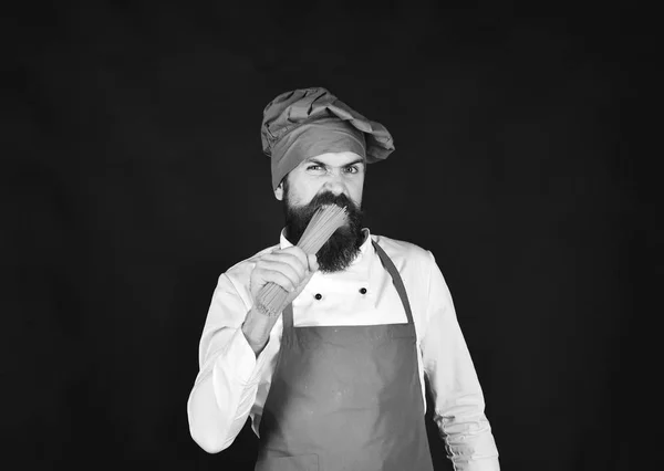 Cuisine italienne concept alimentaire. Homme ou hipster barbu mangeant des pâtes crues ou des macaronis — Photo