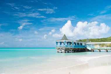 Gelin ve kalın. Deniz turkuaz Teras Su sakin ve bungalow. Tatil deniz kum plaj rahat tropikal ev Bungalov st.johns antigua. Pastoral sahil mavi gökyüzü güneşli gün. Cennet deniz resort