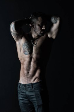 Sporcu altı paketi ve AB dövmeli adam ile seksi kas gövde göster. Pazı ve triceps ile vücut geliştiricisi. Dövme kot pantolon ile manken. Fitness ve spor vintage filtre ile ilgilenmek