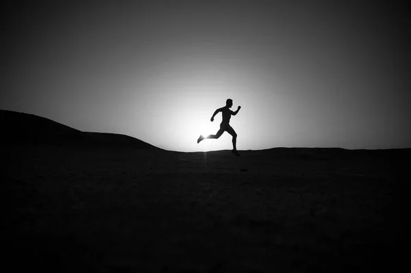 Homem correndo silhueta ao pôr do sol, jovem caucasiano correr na montanha — Fotografia de Stock