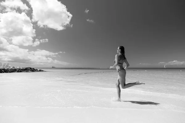 Frau läuft am Strand mit weißem Sand — Stockfoto