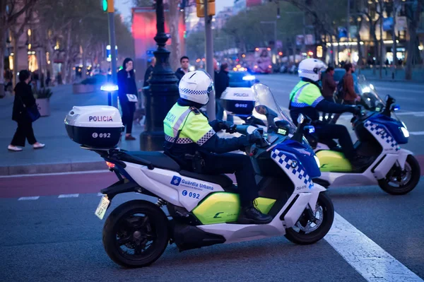 Barselona, İspanya, 30 Mart 2016: trafik polisi akşam kavşak üzerinde motosiklet. Kentsel arka plan üzerinde devriye polisi. Devriye ve polis koruması. Taşıma için polis Barcelona, İspanya