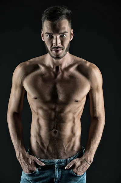 Çekici bir vücut. Kaslı vücutlu, kendine güvenen bir sporcu. Kas kasları gergin kaslar elleri kot pantolonun içine sokar. Maço kaslı göğüs çekici siyah arkaplan