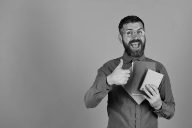 Mutlu yüzü ve kitapları olan adam onaylıyor.