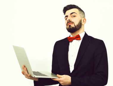 Sakallı meraklı ve gururlu broker beyaz dizüstü bilgisayar tutuyor.