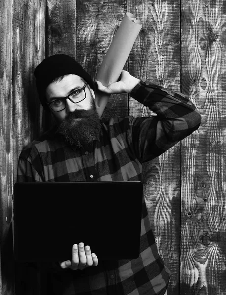 Brutalny, biały hipster trzymający laptopa i papier ręczny — Zdjęcie stockowe
