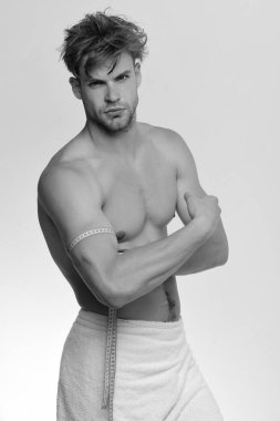 Havlu ve esnek cetveli olan adam beyaz arka planda izole edilmiş.