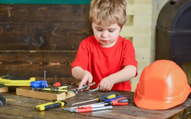 İki uzun metal civata vida fındık ile onun elinde tutan çocuk. Araçları ile oynayan çocuk. Eğitim oyun kavramını