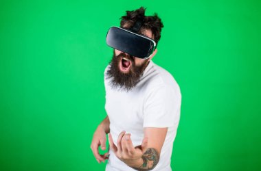 Vr gözlüklü öğrenin gitar müzik çalmak. VR müzisyen kavramı. Hipster gitarist hevesli yüzündeki modern teknoloji eğlence için kullanın. Vr gözlük, yeşil arka planda sakallı
