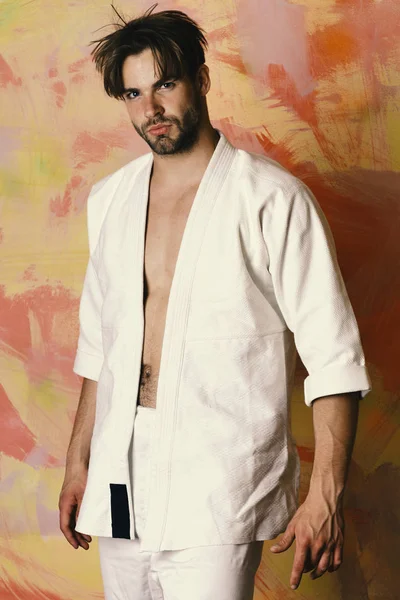 Guy poses in white kimono. Man with confident face