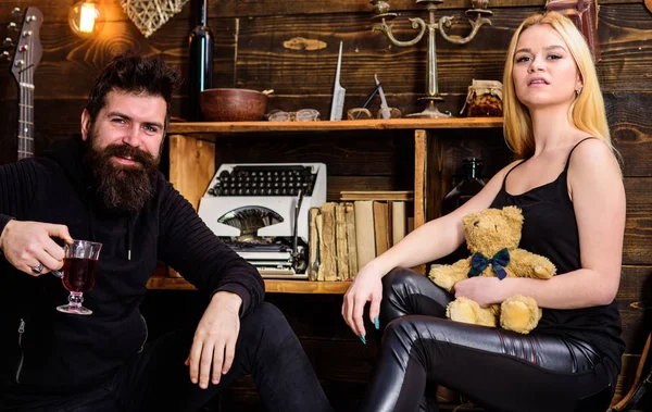 Çift gamekeepers evde, ahşap iç arka plan romantik akşamın. İki aşık oyuncak ayı ve mulled şarap. Rahatlatıcı kavramı. Kız ve adam mutlu yüzler üzerinde sıcak atmosferde dinlenmek