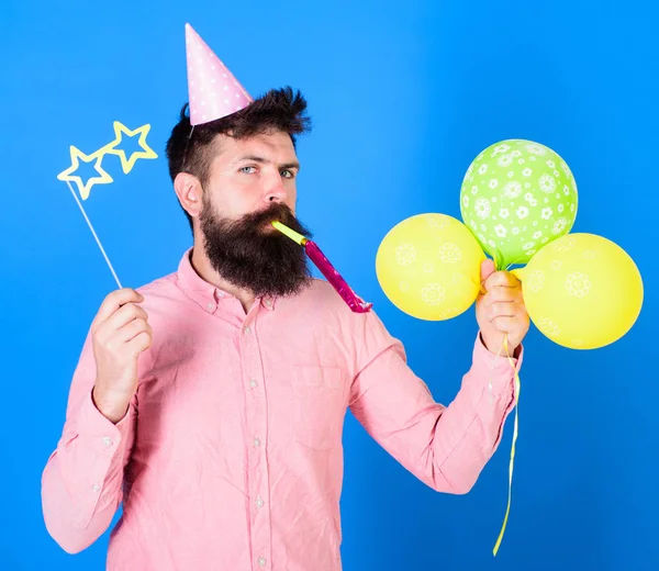 Entertainer mit bunten Luftballons beim Kinderfest, dem internationalen Kindertag. Bärtiger Künstler mit Party-Wahn und papiersternförmiger Brille mit Geburtstagskappe. bärtiger Mann auf blauem Hintergrund — Stockfoto
