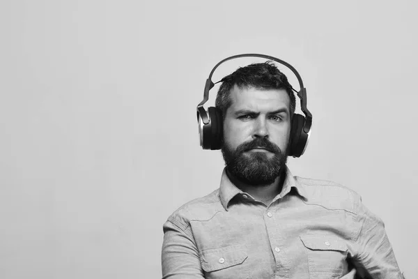 Guy à la barbe et au visage soucieux écoute de la musique — Photo