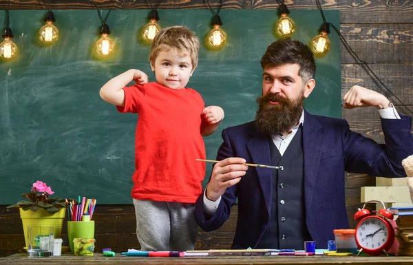 Baba ve oğul kas gösterilen. Baba ve çocuk içeride eğleniyor