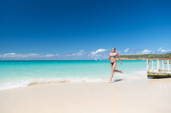 Refrescante y alegre. Chica bikini ejecutar ola azul playa del océano. Vacaciones de lujo tropical océano playa resort. Mujer sexy cuerpo relajarse océano arena blanca playa Antigua. Correr a través de la laguna mágica turquesa — Foto de Stock