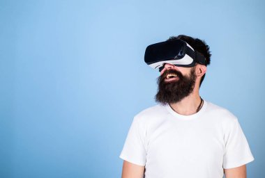 Gülümseyen yüzü üzerinde yenilikçi gadget ile sanal gerçeklik tadını çıkarın. Vr gözlük, açık mavi renkli sakallı adam. Adam kafa monte ekran ile etkileşim içinde sanal gerçeklik. Dijital teknoloji kavramı