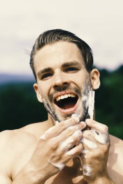 Arka planda odaklı olmayan, konsantre yüzlü maço.