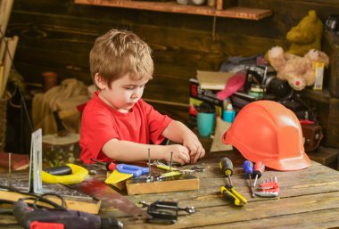 Yürümeye başlayan çocuk meşgul yüzündeki evde araçlarında atölye ile oynuyor. Çocuk Çocuk tamirci oynamak. Çocuk şirin ve sevimli araçlarla builder veya repairer oynarken, onarma veya handcrafting. Çocukluk kavramı