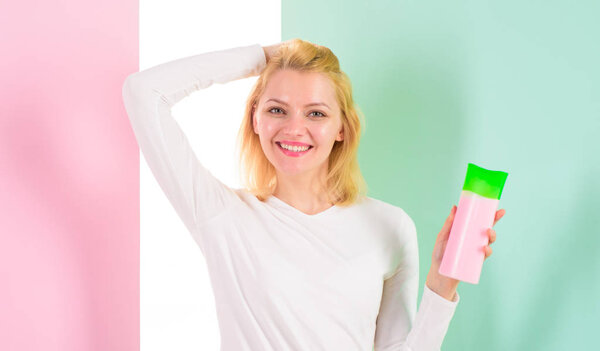 Косметический продукт. Экспертные советы достигают невероятных волос. Как быстро и безопасно восстановить отбеленные волосы. Блондинка держит бутылку шампуня. Мой секрет ухода за волосами. Женщина показывает косметический продукт для волос
