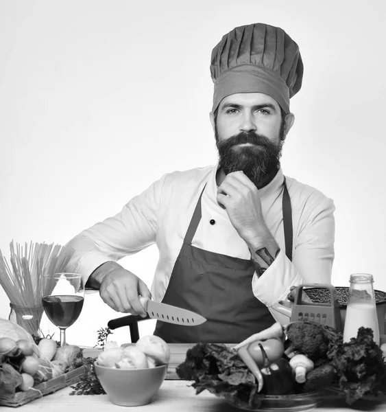 Chef prepares meal. Cook with thoughtful face in burgundy uniform