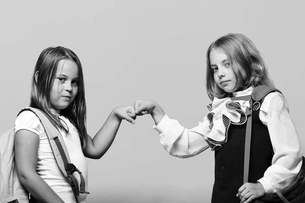Kids wearing schoolbags beat each others fists — Stock Photo, Image