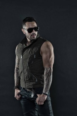 Pazı ve triceps dövmeli adam. Tıraşsız yüzündeki sakallı dövme modeli. Güçlü silah dövme sakallı adam. Moda maço trendy güneş gözlüğü. Moda stil ve eğilim