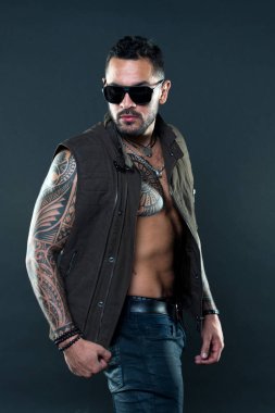 Sakallı adam dövme göğüs ve kollar ile. Tıraşsız yüzündeki sakallı dövme modeli. Dövmeli adam altı paketi ve AB moda stil ve eğilim. Moda maço trendy güneş gözlüğü
