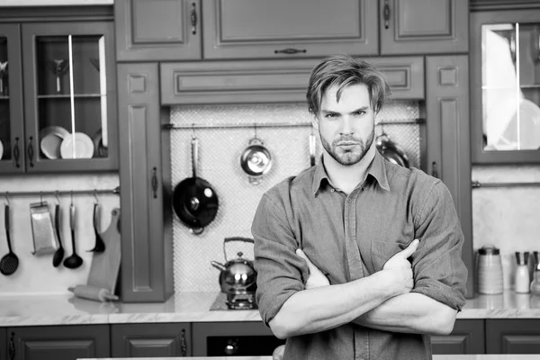 Maço ciddi bir yüz ile stand katlanmış ellerle mutfakta