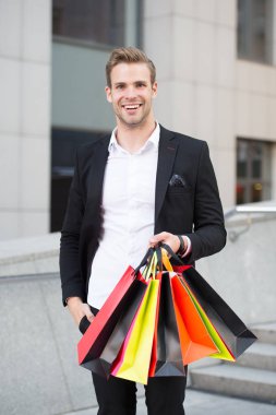 Butik Galeri alışveriş. Adam alışveriş alışveriş torbaları kentsel arka plan taşır. Başarılı bir iş adamı sadece lüks özel yüksek kaliteli markalar ve yüksek moda butiklerinde alışveriş tercih