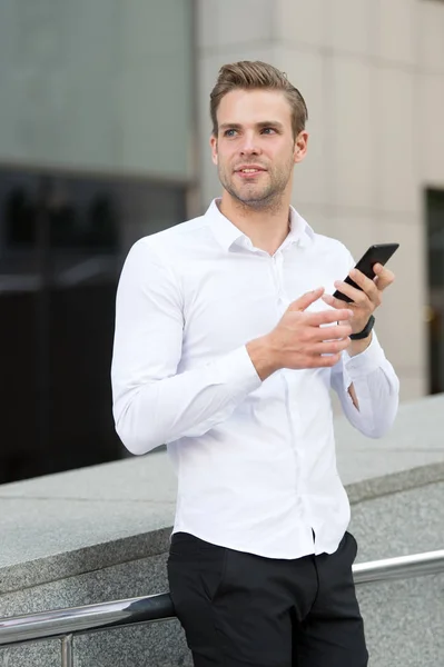 Man checking emails in morning urban background. Businessman send messages or texting with smartphone. Guy handsome attractive businessman networking with smartphone. Smartphone advantages