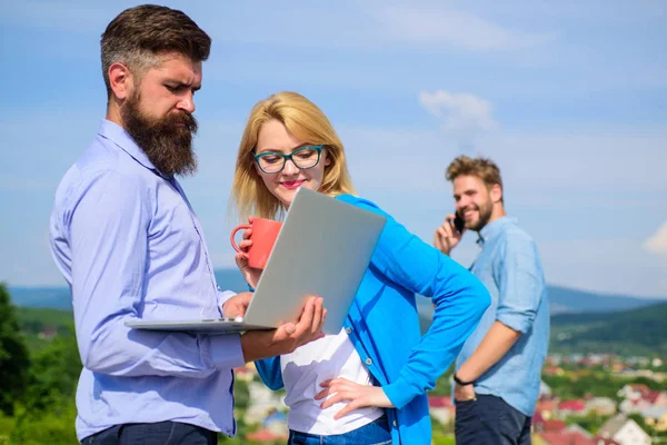 Açık güneşli bir gün, gökyüzü arka plan iş arkadaşları laptop. Arkadaşlar temiz havanın tadını ve çalışmaya devam. Temiz hava zihin yenilemeye yardımcı olur. Meslektaşları ile dizüstü planı tartışıyor. Açık çalışma alanı kavramı — Stok fotoğraf