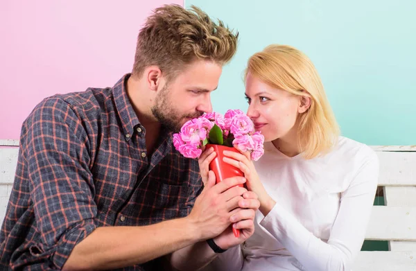 Pleasant surprise for lady. Bouquet favorite flowers as romantic gift. Man gives bouquet flowers to girlfriend, turquoise background. Couple in love romantic date. Gentleman always bring flowers date — Stock Photo, Image