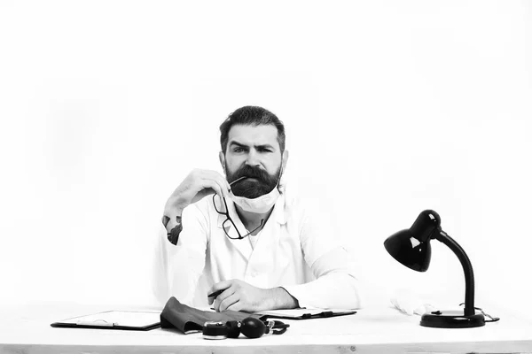Médico caucasiano barbudo sentado à mesa — Fotografia de Stock