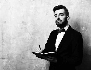 Sakallı işveren, kurnaz bir yüz ifadesi ve şık bir kıyafeti var.