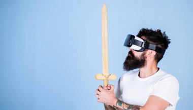 Hipster ciddi bir yüz üzerinde sanal gerçeklik oyun oyun keyfini çıkarın. Vr gözlük, açık mavi renkli sakallı adam. Oyun kavramı. Adam kafa monte ekran ile kılıç, oyun Vr oyunda mücadele tutar