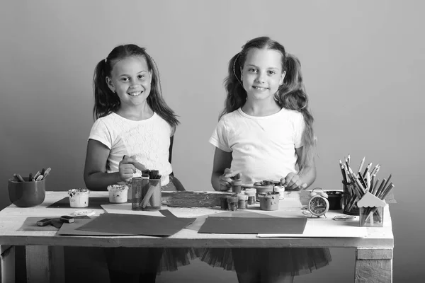 Niños pintan con gouache y marcadores sobre fondo rosa —  Fotos de Stock