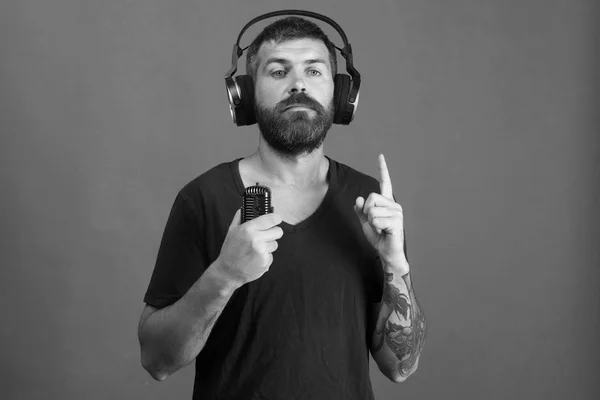 Dj with beard wears headphones, copy space. Music and leisure