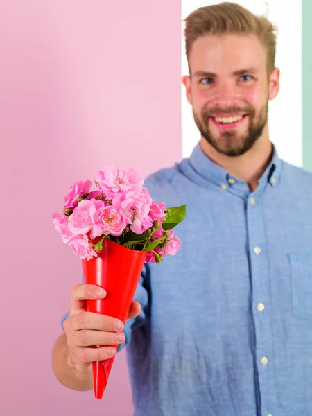 This is for you Macho gives flowers as romantic gift. Boyfriend happy holds bouquet flowers. Guy bring romantic pleasant gift to give. Man ready for romantic date bring bouquet pink flowers