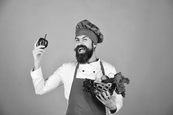 Людина з бородою на червоному тлі. Шеф-кухар тримає салат, помідор , — стокове фото