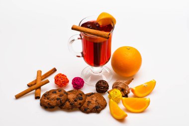 Kokteyl bar kavramı ve. İçki ya da portakal ve tarçın ile içecek. Cam mulled şarap veya portakal dilimleri ve çerezleri beyaz arka plan üzerinde yakın sıcak elma şarabı ile. Portakal dilim yakınındaki mulled şarap