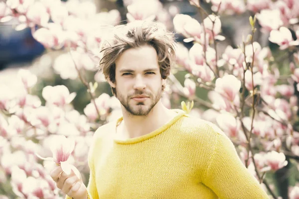Człowiek z brodą w żółty sweterek na tle kwiatów — Zdjęcie stockowe