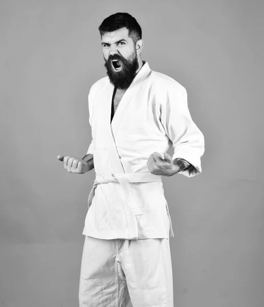 Man with beard in white kimono on red background. — Stock Photo, Image