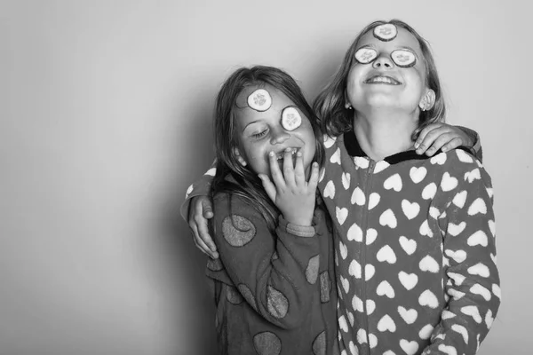 Kinderen met gelukkige gezichten, komkommers op ogen en losse haren — Stockfoto